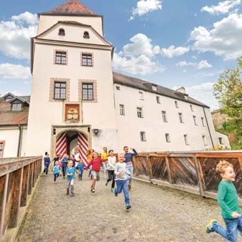 Kinder vor dem Burgtor ©Manfred Rauscher 2016 Kinder laufen aus dem Burgtor über die Zugbrücke.